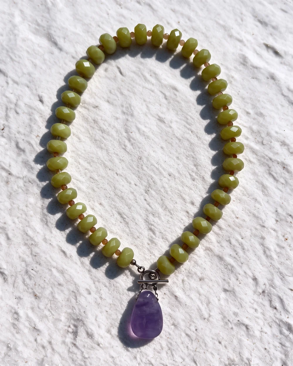 State necklace: large faceted olive-green beads with small amber spacers and a big amethyst pendant on a toggle clasp